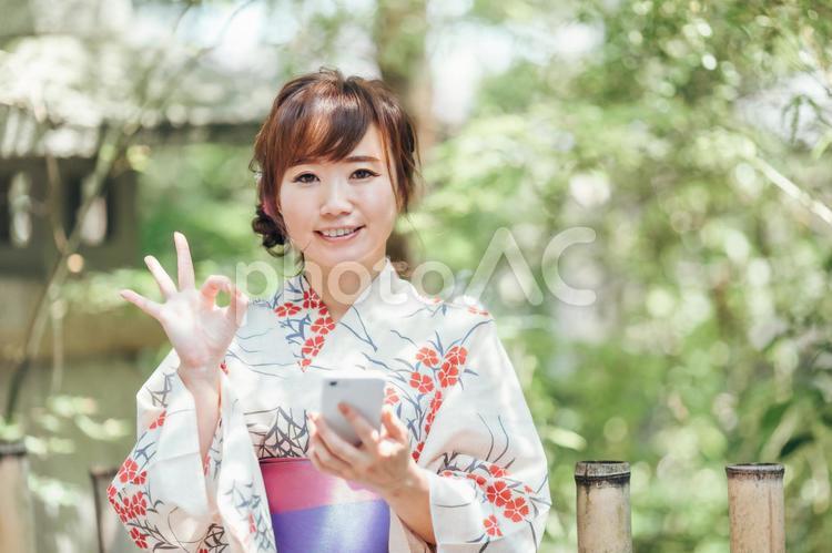スマホを使う浴衣姿の女性 浴衣,スマホ,ゆかたの写真素材