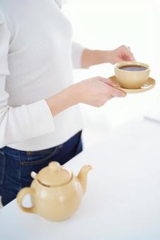 カップをソーサーを持つ人の手の写真