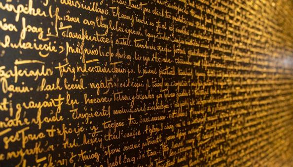 黒色の壁に刻まれた金色の文字の写真