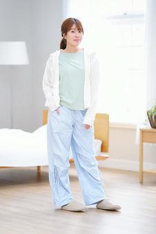 カメラ目線で片手をポケットに入れポーズする女性 女性,微笑む,ポケットの写真素材