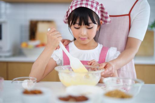 ボウルで生地を混ぜる笑顔の女の子 女の子,小学生,日本人の写真素材