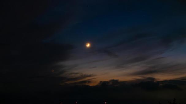 夕焼けに照らされし月 夕焼け,月,空の写真素材