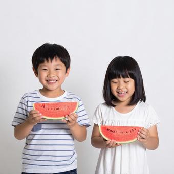 スイカを食べる子供たちの写真