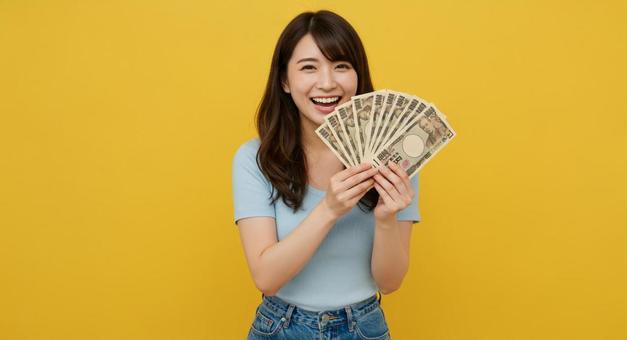 大金を手にして喜ぶ女性 大金を手にして喜ぶ女性の写真