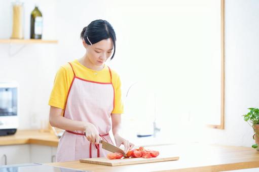 包丁でトマトを切っている女性 女性,トマト,切るの写真素材