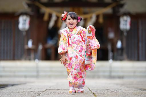 晴れ着姿で笑顔を見せる幼い女の子の参拝シーン 晴れ着姿で笑顔を見せる幼い女の子の参拝シーンの写真