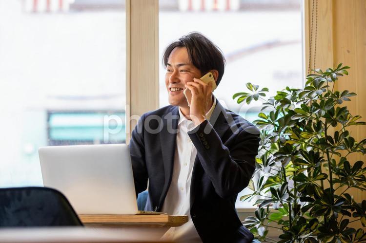 仕事するビジネスマン（笑顔） ビジネスマン,ビジネス,スマホの写真素材