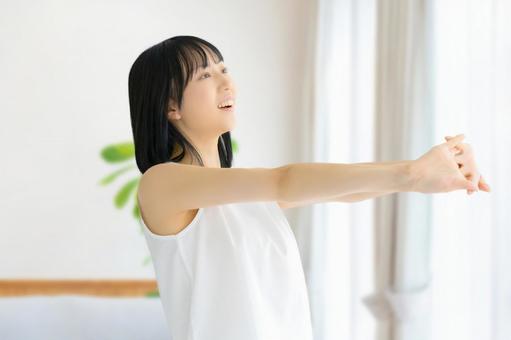 リビングでストレッチをする若い女性 リビングでストレッチをする若い女性 女性,美容,健康の写真素材