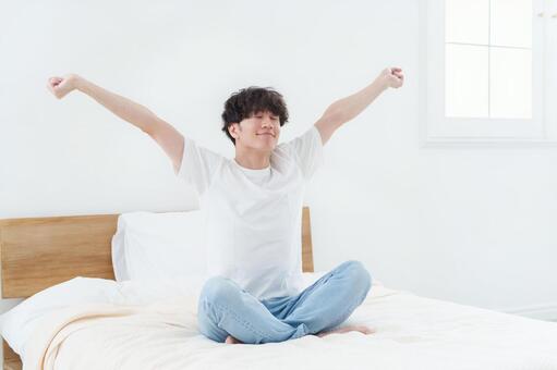 ベッドでストレッチをする男性 男性,ベッド,寝室の写真素材