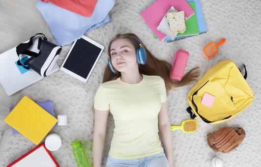 仰向けでリラックスしながら音楽を楽しむ女性 女性,仰向け,寝転ぶの写真素材