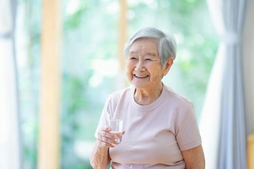 右手にコップを持ち笑うショートヘアの女性 女性,コップ,水の写真素材