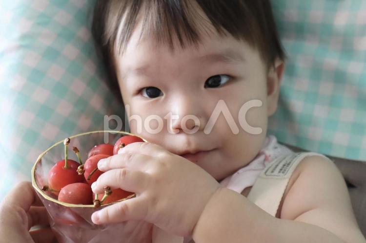 赤ちゃん、さくらんぼに手を添えて 赤ちゃん,さくらんぼ,ニコニコの写真素材