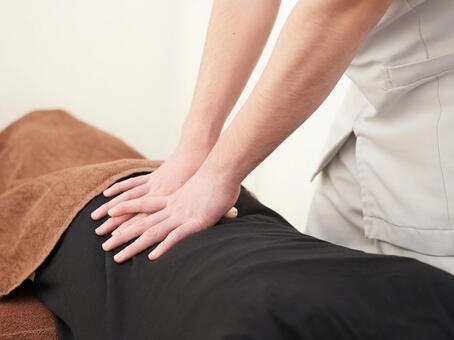 Japanese woman receiving a waist massage Japanese woman receiving a waist massage