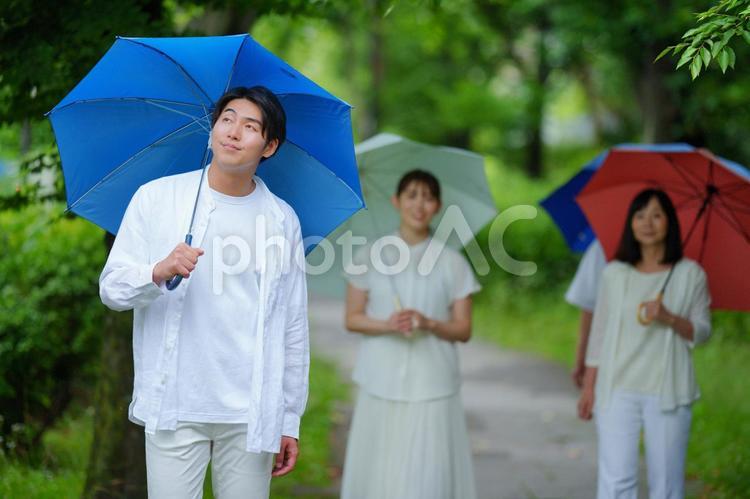 傘をさし遠くを見る男性 男性,傘,雨の写真素材