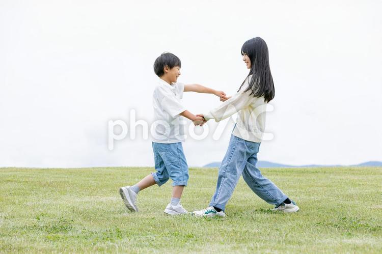 緑の丘の上で笑顔を見せる子ども 子ども,笑顔,スマイルの写真素材