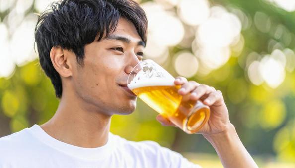 ビールを飲む若い男性のポートレート ビールを飲む若い男性のポートレートの写真