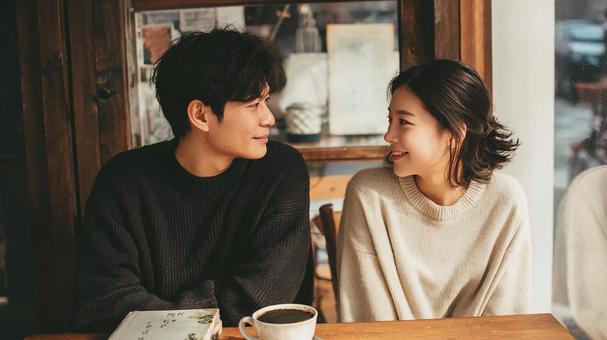 カフェで笑顔を見つめ合う二人 カフェで笑顔を見つめ合う二人の写真
