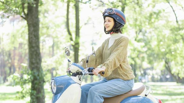 バイクに乗る若い女性 バイクに乗る若い女性の写真