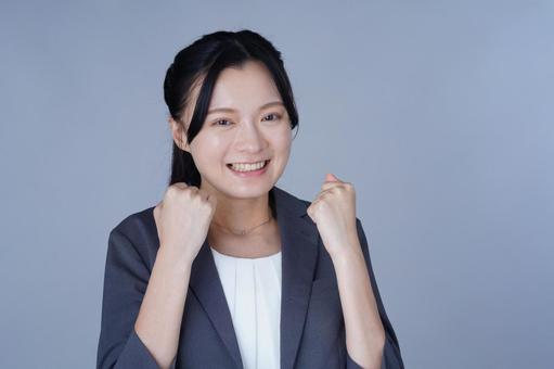 グレーの服の女性が両手を握るの写真