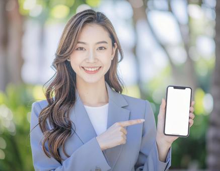 スマホを持つ笑顔の女性5 スマホを持つ笑顔の女性5の写真