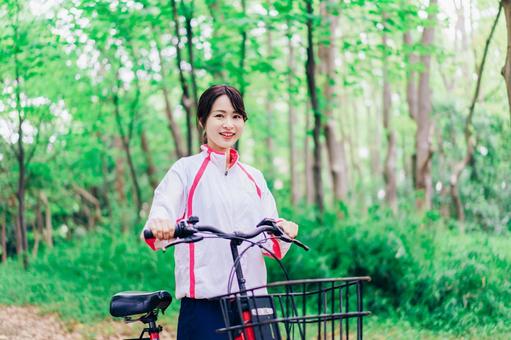 自然の中でサイクリングを楽しむ若い女性 自然の中でサイクリングを楽しむ若い女性 チャリ,運動,自転車の写真素材