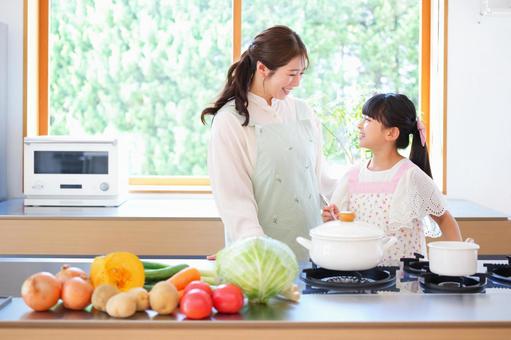 コンロの前で話している笑顔の親子 コンロの前で話している笑顔の親子の写真