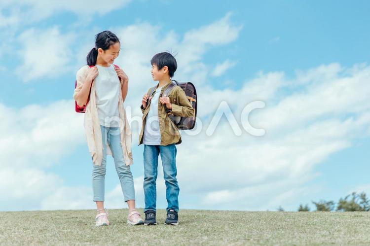 空と小学生の男女 小学生,空,子供の写真素材