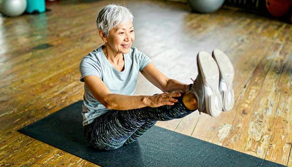 前屈のストレッチをするシニア女性 前屈のストレッチをするシニア女性の写真