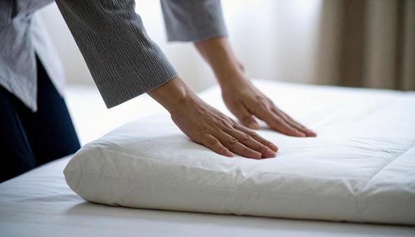 布団にカバーをかぶせている日本人女性 の写真