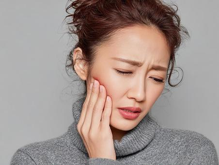 不安げに顔を押さえる日本人女性 不安げに顔を押さえる日本人女性の写真
