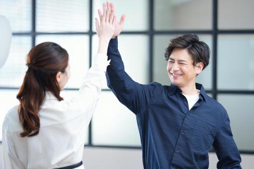 笑顔で女性とハイタッチをする男性 笑顔で女性とハイタッチをする男性 男女,ハイタッチ,笑顔の写真素材