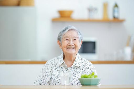 シャインマスカットと笑顔の高齢女性 女性,笑顔,シャインマスカットの写真素材