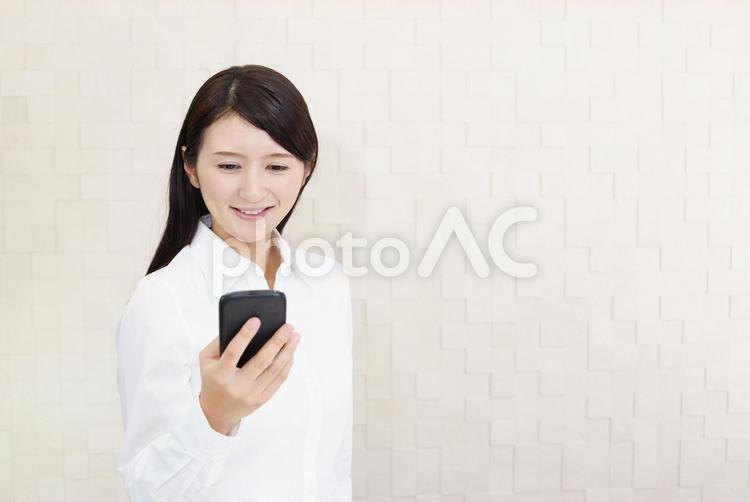 スマートフォンを持つ微笑む女性 女性,スマートフォン,女の写真素材