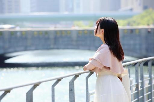 川沿いで景色を眺める女性 川沿いで景色を眺める女性 女性,若い,20代の写真素材