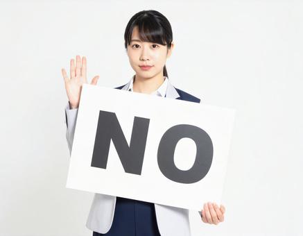 Noと書かれたボードを持つ女性社員 Noと書かれたボードを持つ女性社員の写真