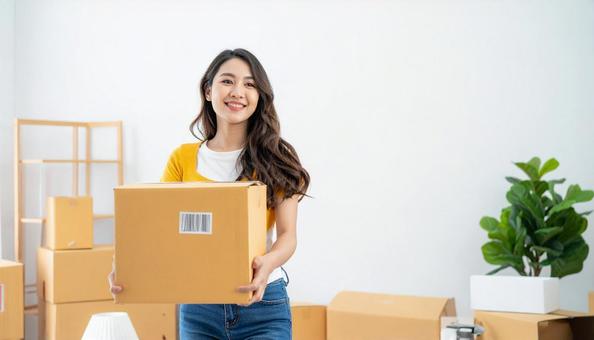 微笑みながら引越し作業をする女性の写真