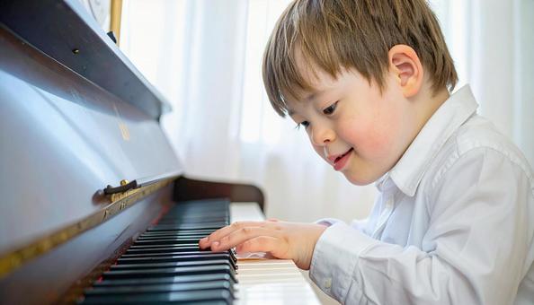 ピアノを弾くダウン症の少年 ピアノを弾くダウン症の少年の写真
