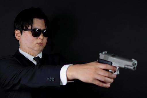 銃を構えるスーツ男性 銃を構えるスーツ男性 男性,スーツ,銃の写真素材