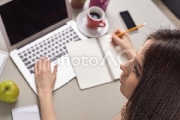 女性とノートパソコン(俯瞰)1 女性,書く,ノートの写真素材