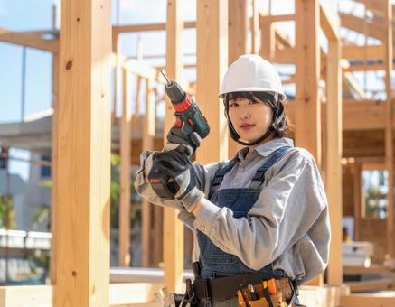 家を建築中の若い女性大工 家を建築中の若い女性大工の写真