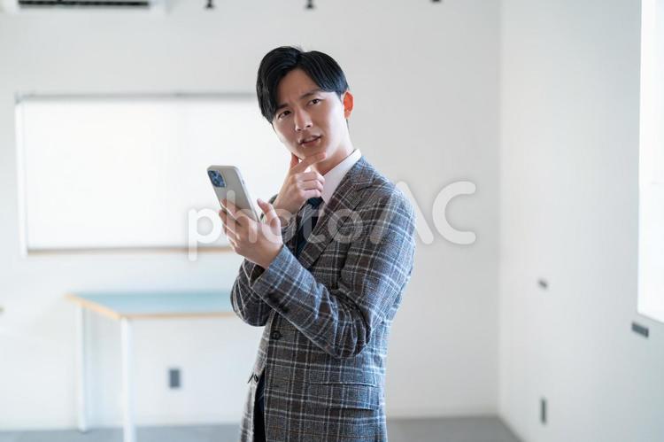 携帯を持つ男性 営業,男性,ビジネスマンの写真素材