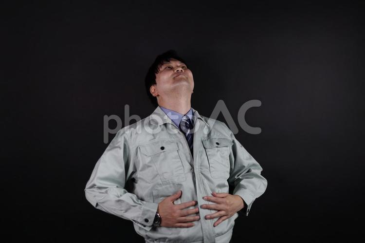 作業服の男性が満足げにお腹を押さえる姿 作業員,男性,作業服の写真素材