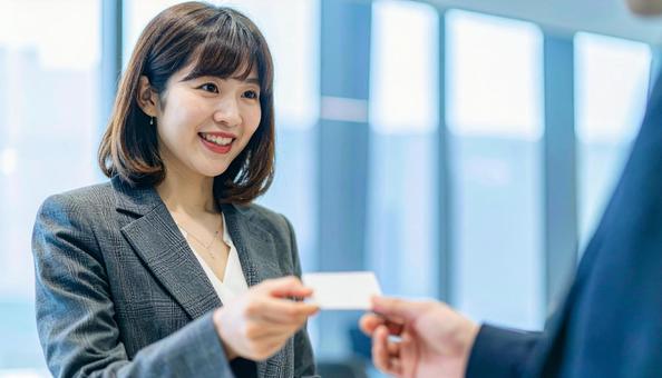 笑顔で名刺交換をするビジネス女性 笑顔で名刺交換をするビジネス女性の写真