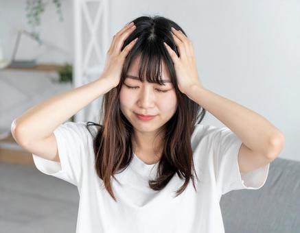 頭を抱える女性 頭を抱える女性の写真