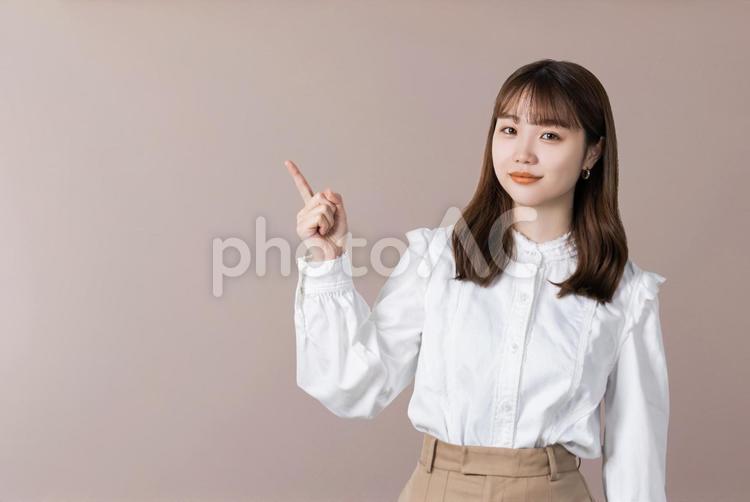 人差し指を立てて案内するビジネスウーマン 女性,ビジネス,笑顔の写真素材