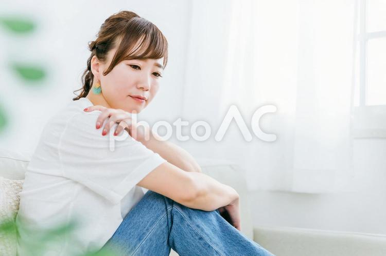 部屋でうつ病・体調不良に悩む日本人女性 憂鬱,悩む,困るの写真素材