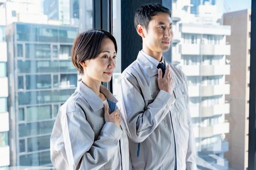 胸に手を当てる作業着を着た男女 胸に手を当てる作業着を着た男女 ビジネスマン,男性,建設の写真素材