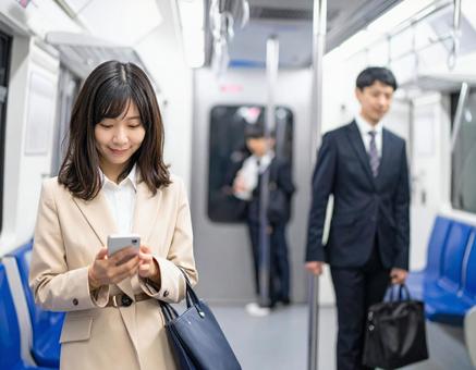 ビジネスシーン・地下鉄出張、スマホを見る ビジネスシーン・地下鉄出張、スマホを見るの写真
