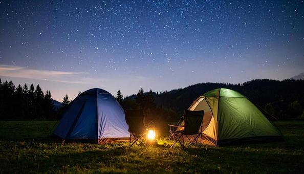 夜の星空の下の焚き火とテントキャンプ 夜の星空の下の焚き火とテントキャンプの写真