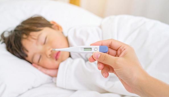 体温計を持つ母親の手と体調不良の子供 体温計を持つ母親の手と体調不良の子供の写真